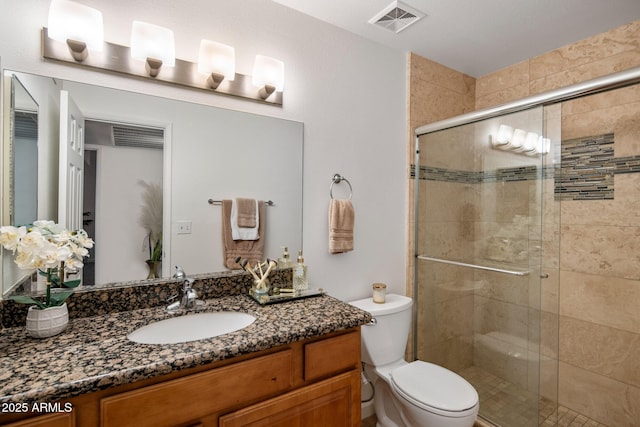 bathroom featuring toilet, an enclosed shower, and vanity