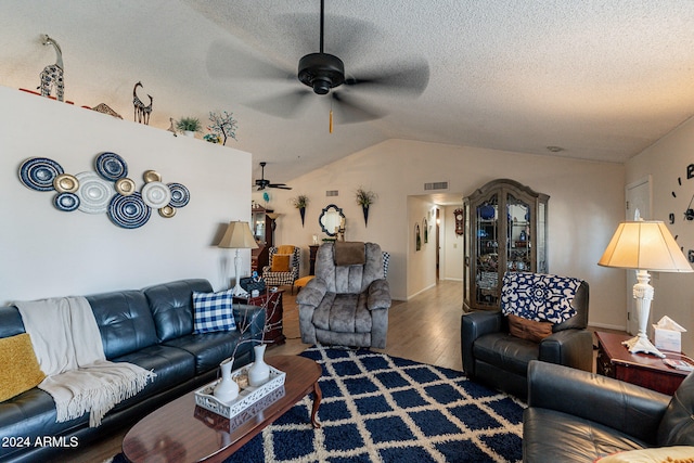 living room featuring hardwood / wood-style flooring, ceiling fan, a textured ceiling, and vaulted ceiling