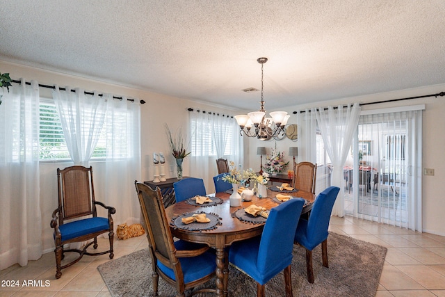 tiled dining space with a textured ceiling and an inviting chandelier