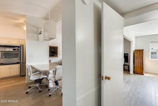 interior space featuring light wood-style flooring, baseboards, and stainless steel appliances