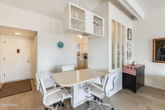 dining area with light wood finished floors and baseboards