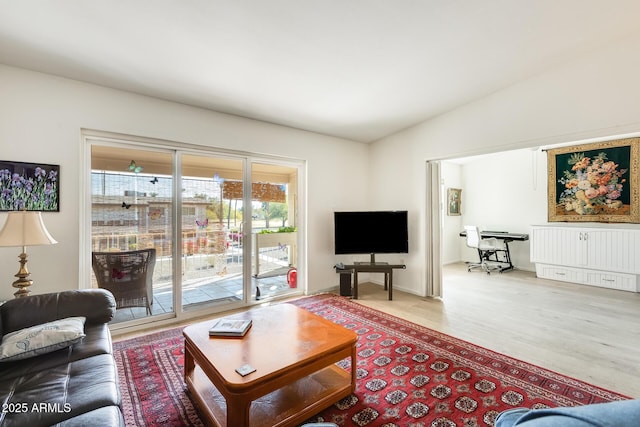 living area with wood finished floors and vaulted ceiling