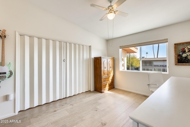 interior space with vaulted ceiling, baseboards, light wood-type flooring, and ceiling fan