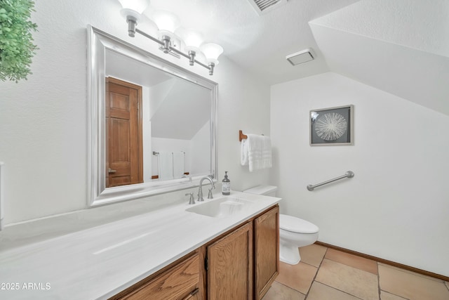 bathroom with a textured ceiling, lofted ceiling, tile patterned flooring, vanity, and toilet