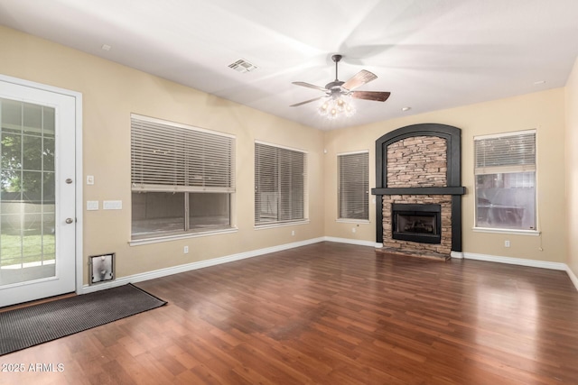 unfurnished living room featuring wood finished floors, a ceiling fan, a fireplace, and baseboards