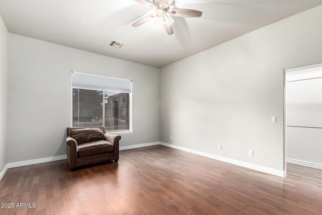 unfurnished room with ceiling fan, wood finished floors, and baseboards