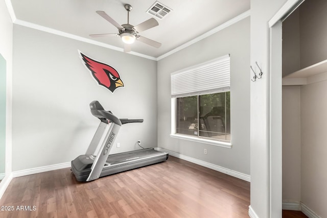 exercise area with wood finished floors, ceiling fan, crown molding, and baseboards