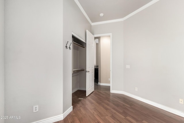 unfurnished bedroom with dark wood-type flooring, crown molding, and baseboards