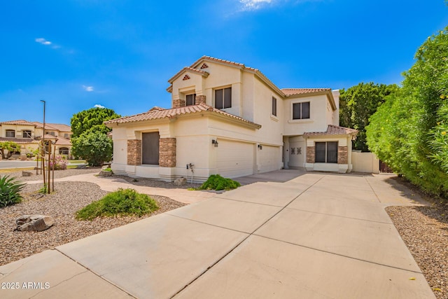 mediterranean / spanish house with a tile roof, stucco siding, driveway, fence, and a garage