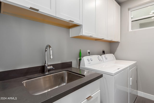 laundry area featuring washer and clothes dryer, sink, and cabinets