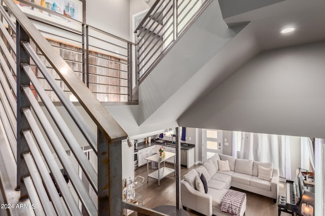 staircase featuring a high ceiling and hardwood / wood-style flooring