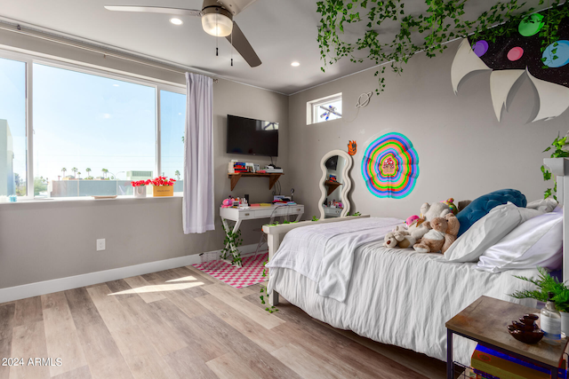 bedroom featuring light wood-type flooring, multiple windows, and ceiling fan