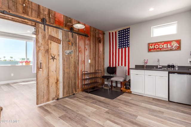 bar with white cabinets, dishwasher, plenty of natural light, and a barn door