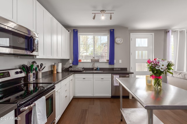 kitchen featuring stainless steel appliances, white cabinets, sink, and dark hardwood / wood-style flooring