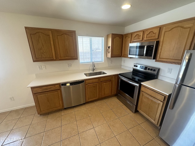 kitchen with sink, stainless steel appliances, and light tile patterned flooring