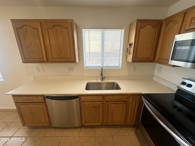 kitchen with sink, light tile patterned floors, and stainless steel appliances