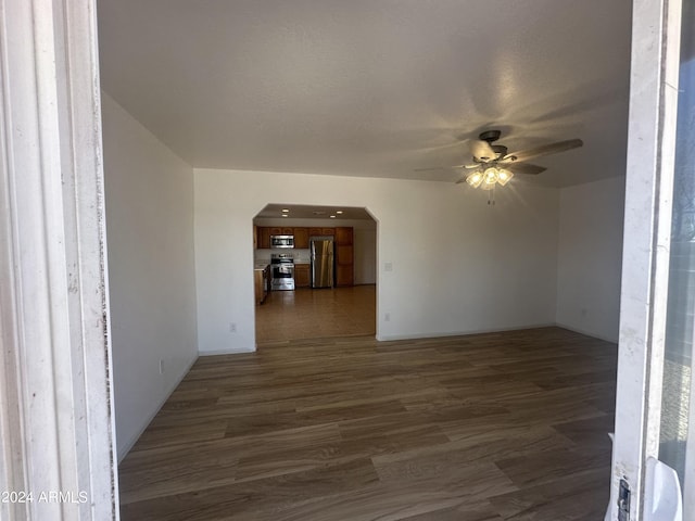 unfurnished living room featuring ceiling fan and dark hardwood / wood-style floors