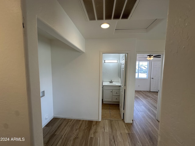 hallway with wood-type flooring and sink