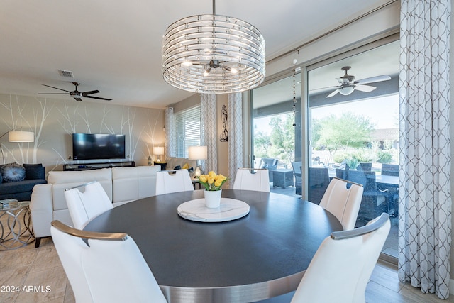 dining room featuring ceiling fan with notable chandelier