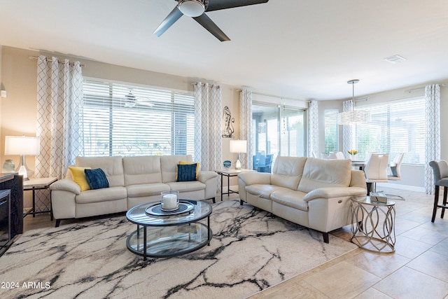 tiled living room with ceiling fan and a wealth of natural light