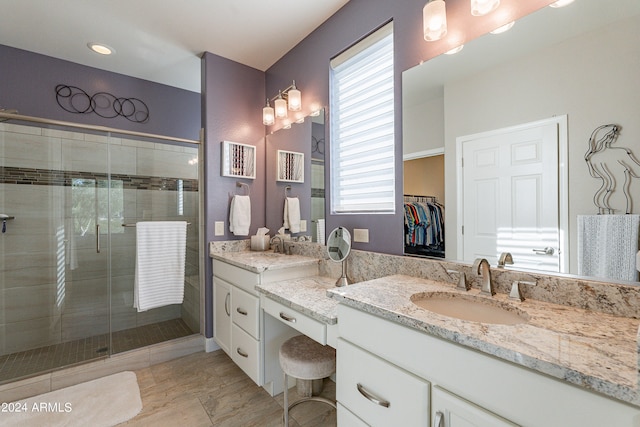 bathroom with vanity, an enclosed shower, and a wealth of natural light