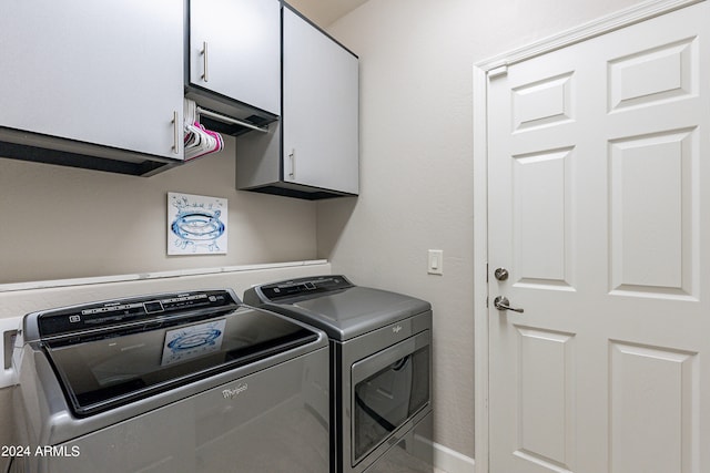 laundry area with separate washer and dryer and cabinets