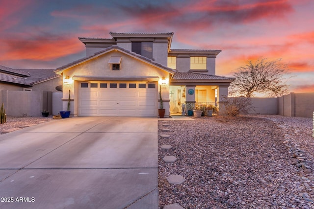 view of front of home with stucco siding, fence, a garage, driveway, and a tiled roof