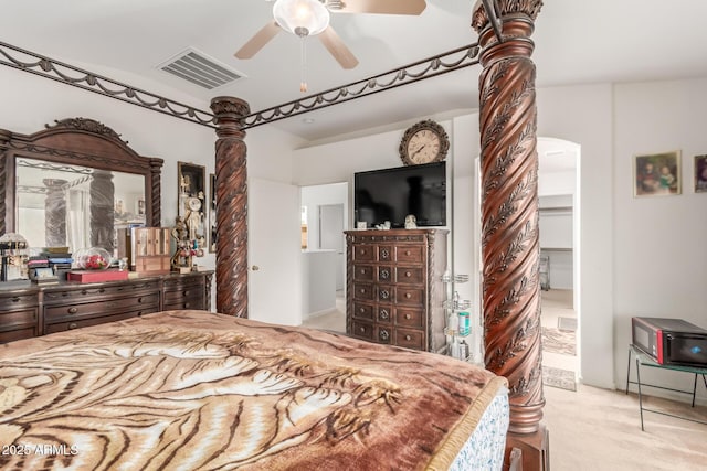 bedroom featuring arched walkways, a ceiling fan, visible vents, and light colored carpet