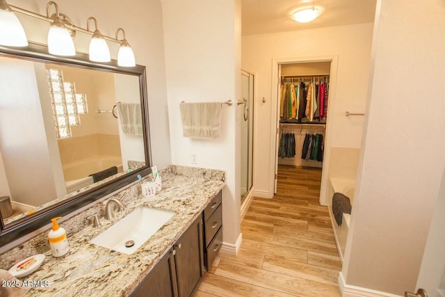 bathroom featuring vanity, independent shower and bath, and hardwood / wood-style floors