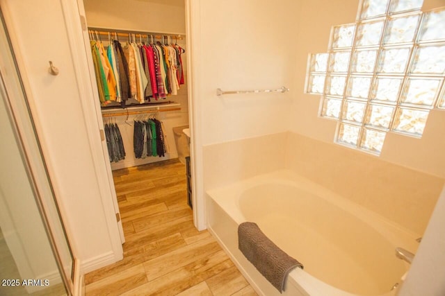 bathroom with a bathing tub and hardwood / wood-style floors