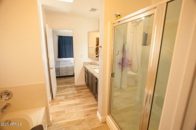 full bathroom with vanity, hardwood / wood-style floors, toilet, and separate shower and tub