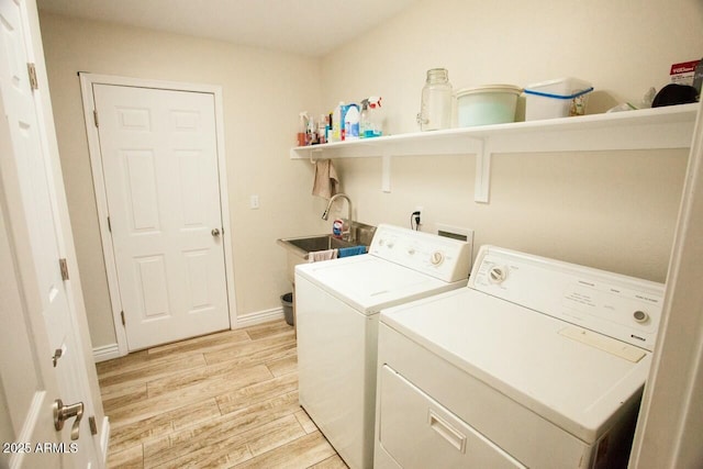 clothes washing area with sink and independent washer and dryer