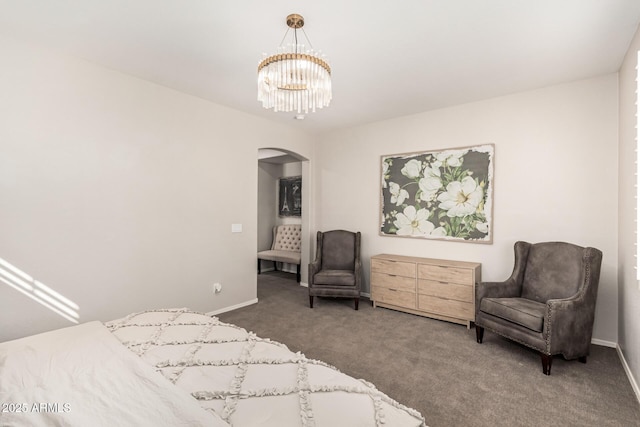 bedroom featuring dark colored carpet and an inviting chandelier