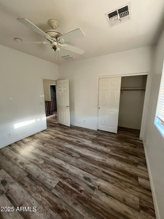 unfurnished bedroom featuring visible vents, a closet, dark wood-style flooring, baseboards, and ceiling fan