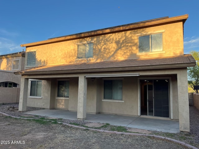 rear view of house featuring a patio area and stucco siding
