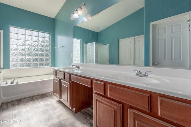 full bathroom featuring double vanity, a sink, a bath, and lofted ceiling