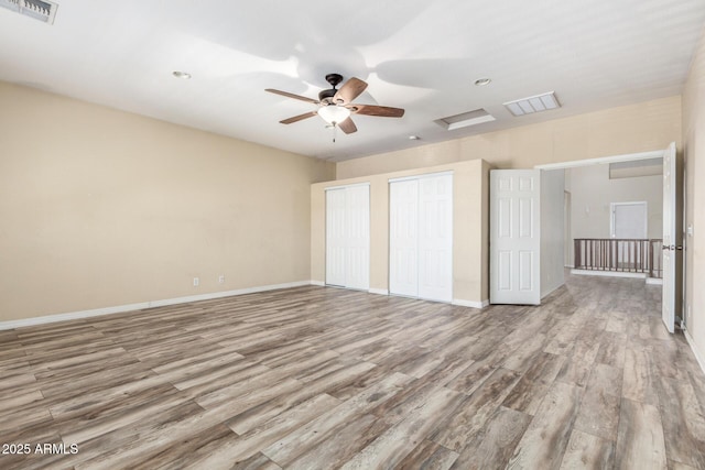 unfurnished bedroom with baseboards, visible vents, and wood finished floors
