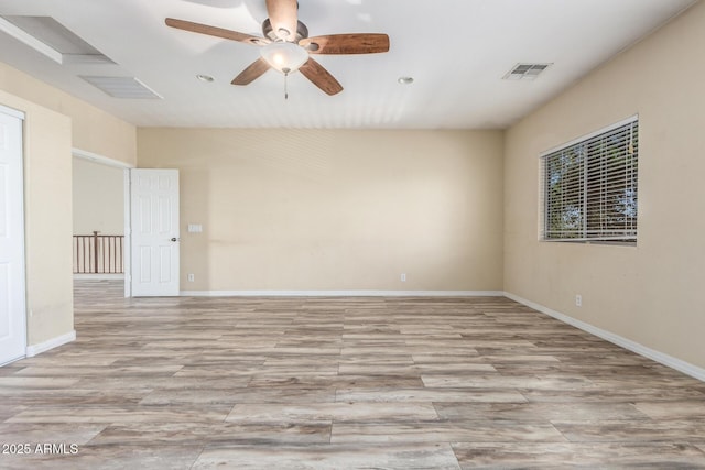 empty room with baseboards, a ceiling fan, light wood-type flooring, and visible vents