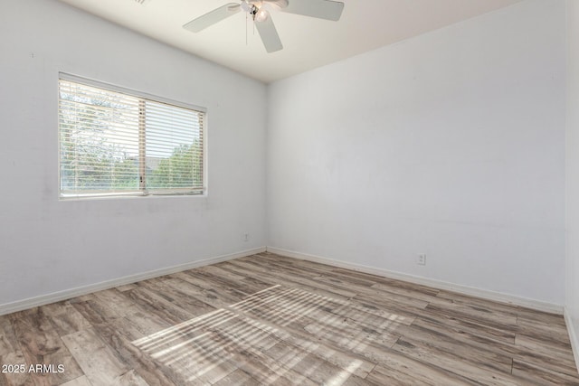 spare room featuring baseboards, a ceiling fan, and wood finished floors