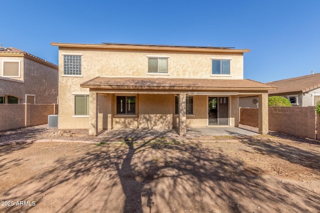 back of property featuring a fenced backyard, roof mounted solar panels, a patio area, and stucco siding