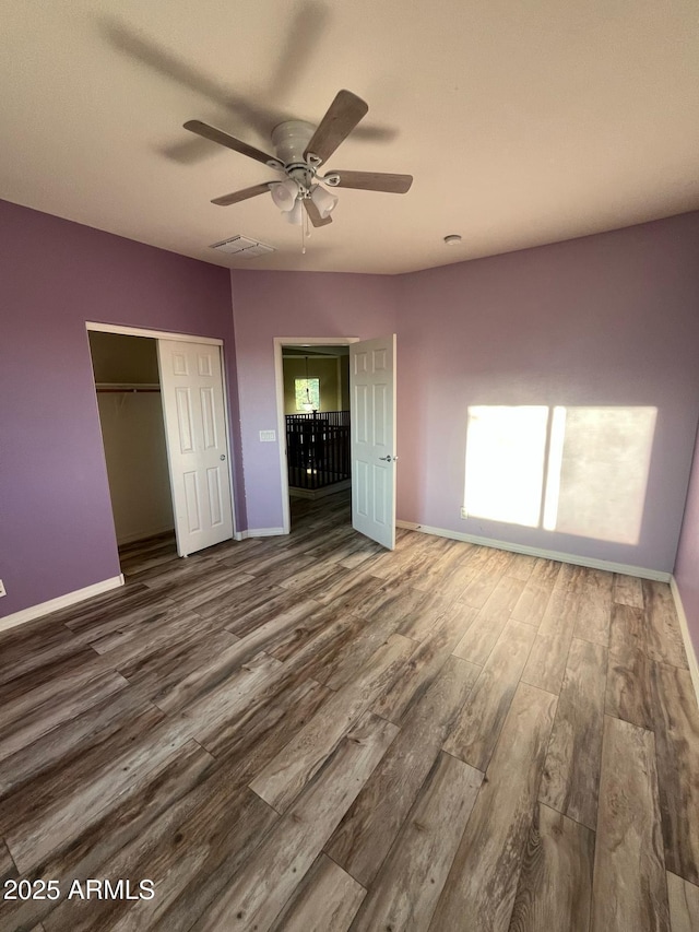 unfurnished bedroom featuring baseboards, a closet, and wood finished floors