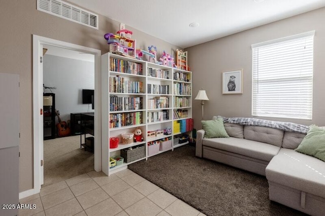 sitting room with light colored carpet, visible vents, and light tile patterned floors