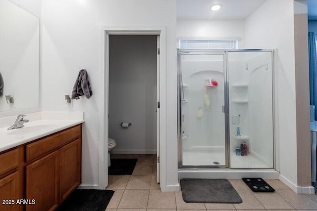 full bath with toilet, vanity, baseboards, tile patterned floors, and a stall shower