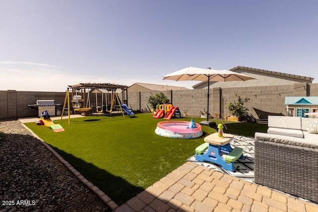 view of yard featuring a patio area, a fenced backyard, outdoor lounge area, and a playground