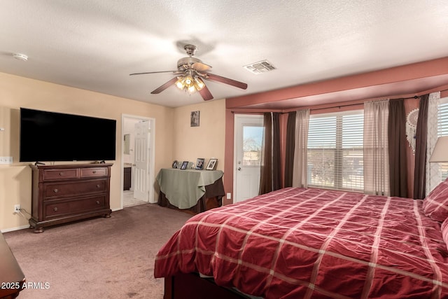 carpeted bedroom with a textured ceiling, ceiling fan, and connected bathroom