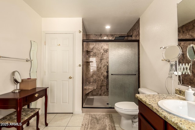 bathroom featuring toilet, a shower with door, vanity, and tile patterned flooring