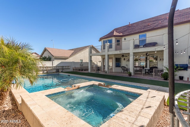 view of swimming pool with ceiling fan, an in ground hot tub, and a patio