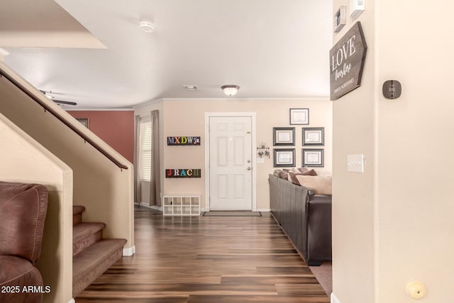 entryway featuring dark wood-type flooring and ornamental molding