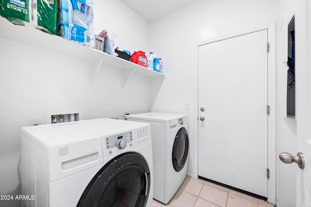 laundry room featuring washing machine and dryer and light tile patterned floors