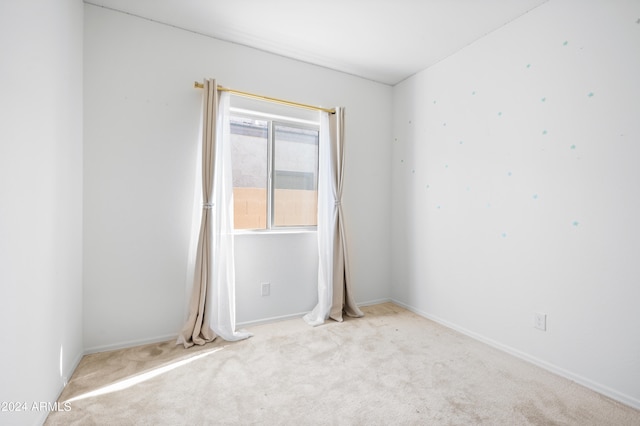 spare room featuring light carpet